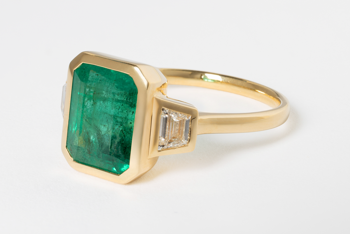 6.64 EMERALD AND DIAMOND THREE-STONE RING