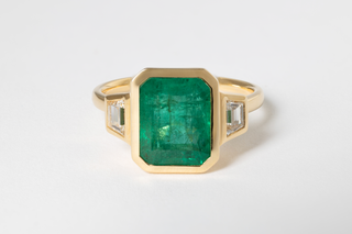 6.64 EMERALD AND DIAMOND THREE-STONE RING