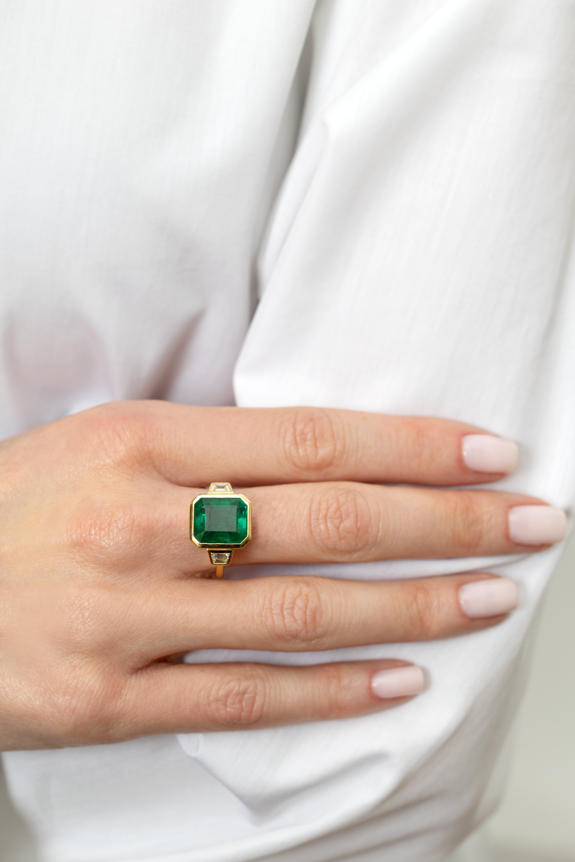 6.64 EMERALD AND DIAMOND THREE-STONE RING